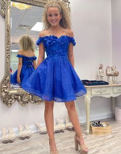 Embrace timeless elegance with the Sparkly Royal Blue A-Line Off-the-Shoulder Beaded Flowers Homecoming Dress. With a flattering A-line silhouette, this dress is crafted from delicate lace fabric with intricate appliqued beaded flowers that shimmer with every step, making you the center of attention at any event. A striking royal blue color that exudes sophistication and glamor. Details: Silhouette: A-Line Style Fabric: Lace Fabric Color: Royal Blue Color Length: Short-Mini Length Neckline: Off- Dresses With 3d Flowers, Royal Blue Homecoming Dress, Floral Lace Shorts, White Homecoming Dresses, Blue Homecoming Dresses, Sequin Appliques, Blue Tulle, Royal Blue Dresses, Royal Blue Color