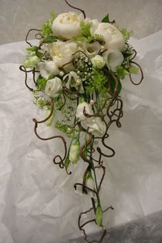 a bridal bouquet with white flowers and greenery