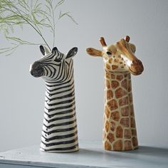 two giraffes and a zebra standing next to each other on a white background