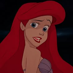 ariel from the little mermaid with blue eyes and red hair, smiling at the camera