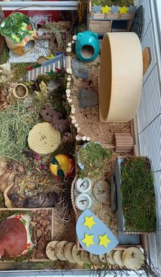 a toy train set with lots of plants and toys in the back ground next to it