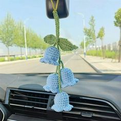 a car dashboard with blue flowers hanging from the dash board