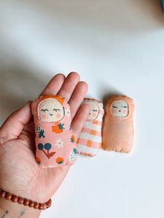 two small dolls are held in the palm of someone's hand