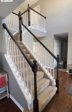 a white staircase with black railing and handrails