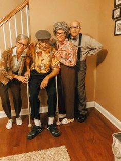 three older people are standing in front of a stair case and posing for the camera