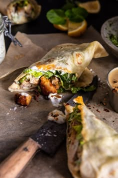 a burrito cut in half and sitting on top of a cutting board next to a knife