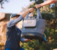 a person holding a bag with the word yet on it and another hand reaching for it