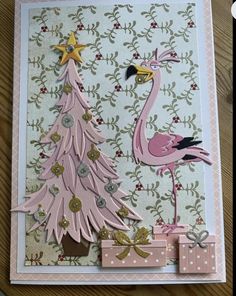 a card with a pink flamingo next to a christmas tree