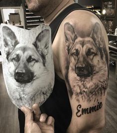 a man is holding up two pictures of dogs on his arm