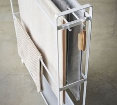 a towel rack with two towels hanging from it's sides and one folded up