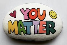 a painted rock with the words you matter written on it and smiley faces in different colors