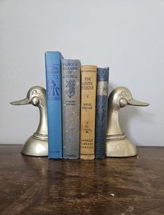 three books are stacked on top of each other in the shape of two duck heads