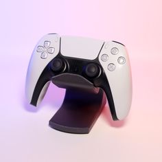 a close up of a nintendo wii game controller on a white table with pink and blue background