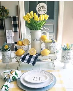 the table is set with yellow flowers and lemons