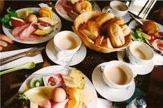 a table topped with plates and cups filled with food