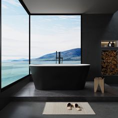 a bathroom with a large window and a black bathtub next to a white rug