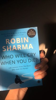 a person holding up a book in front of their face with the title who will cry when you die?