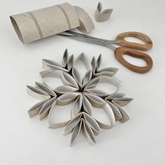 paper flowers and scissors on a white surface