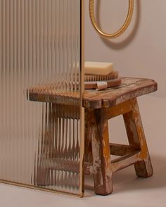 an old wooden table with a glass door on the side and a round mirror behind it