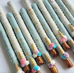 there are many blue and white candy sticks with flowers on them in the shape of unicorn tails