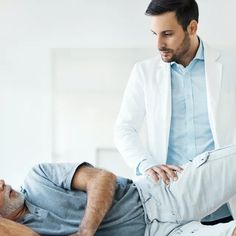 a man receiving a back massage from a physcaroneic doctor in a white coat