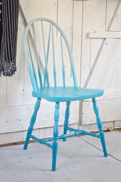 a blue chair sitting in front of a white door