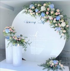 two tall vases with flowers on them are sitting in front of a white backdrop