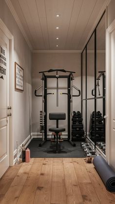 a home gym with exercise equipment and yoga mat on the floor in front of it