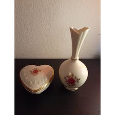 two white vases with red roses on them and a heart shaped box in the middle