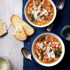 two bowls of soup with bread on the side