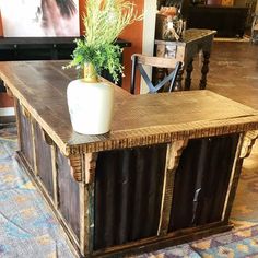 a plant is sitting on top of a wooden table in the middle of a room