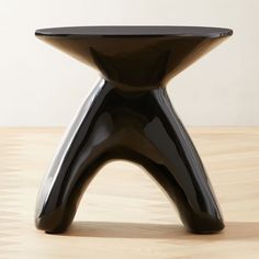 an unusual black table on a wooden floor