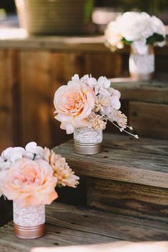 three vases filled with flowers sitting on top of some wooden steps next to each other