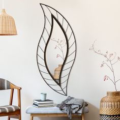 a room with a table, chair and vase on the floor next to a wall