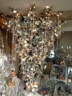 a christmas tree is hanging from the ceiling in front of many other ornaments and decorations