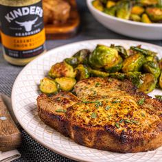 a white plate topped with meat and brussel sprouts