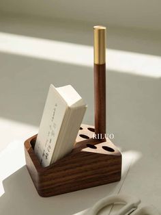 a wooden pen holder with two pens in it