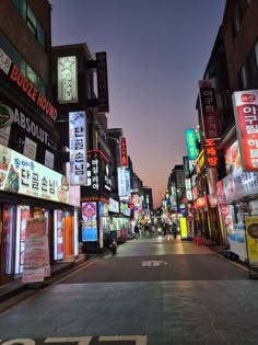 an empty city street at night with neon signs