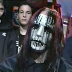 a man with his face painted white and wearing a skeleton mask in front of other men