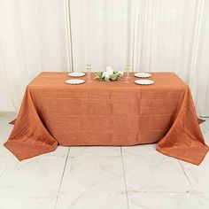 an orange table cloth with white plates on it