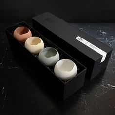 three eggs in a black box on a table