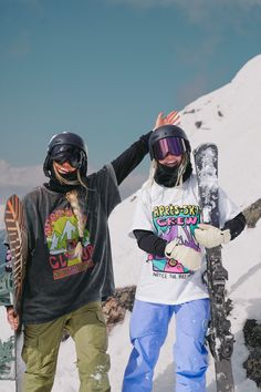 two snowboarders are standing in the snow with their skis and gear on