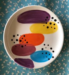 a white plate with multicolored circles painted on it