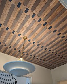 the ceiling is made out of wood planks and has a chandelier hanging from it