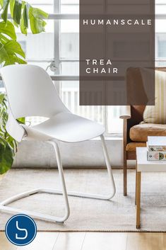 a white chair sitting in front of a window next to a table with a magazine on it