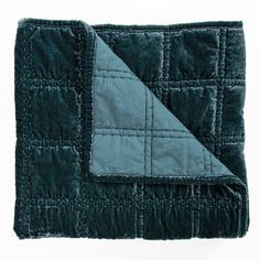 a blanket that is folded up on top of a white surface with a black and blue patch