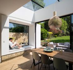 a man sitting at a table in front of a large glass window looking out onto the backyard