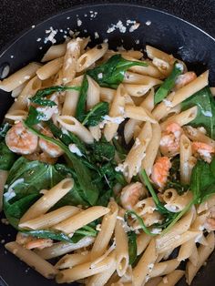 pasta with shrimp, spinach and fettuccine in a black skillet