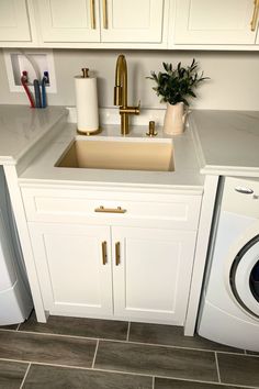 a washer and dryer sitting next to each other in a room with white cabinets