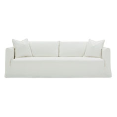 a white couch with four pillows on it's back and one pillow in the middle